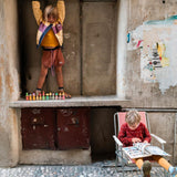 Girl stood on a concrete shelf next to some Grapat Fancy Nin waldorf figures