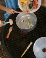 Children are using the Grapat Wooden Sensory Play Tools to make a meal. One child is pouring in lentils