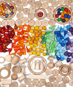 A variety of natural and coloured handcrafted Grapat wooden loose pieces laid in a decorative flatlay