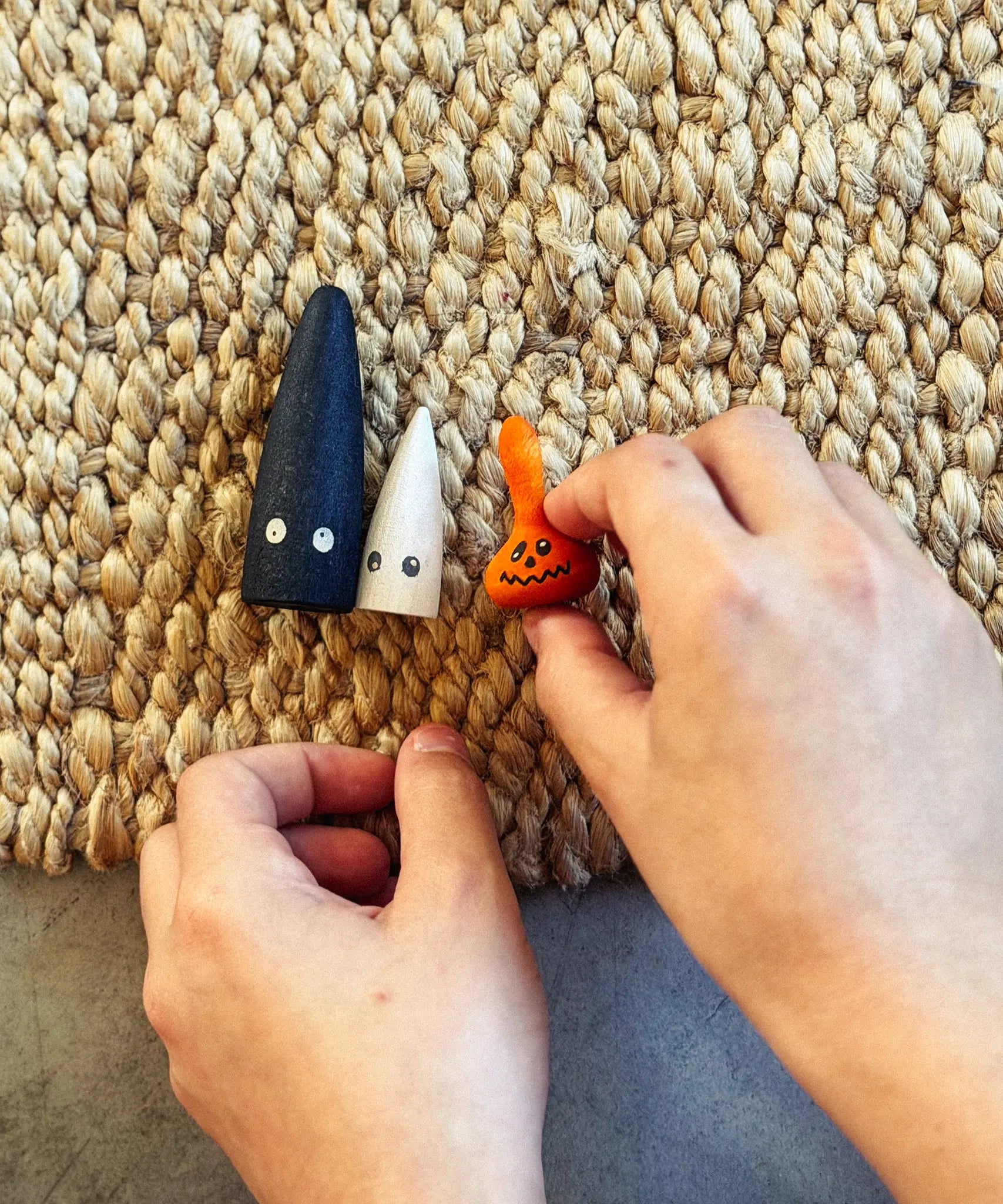 Child's hands playing with the Grapat Lucky Lucky mystery toy box number 13 boo in the dark set of wooden toys. 