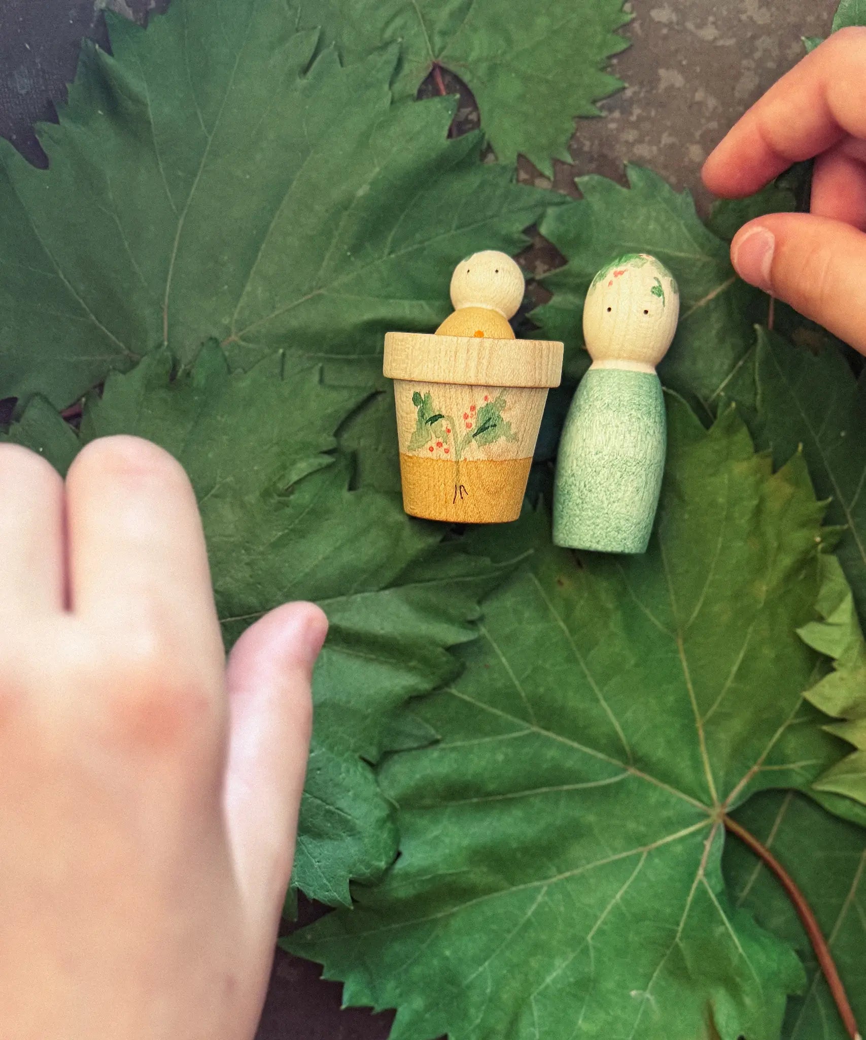 Child's hand playing with the Grapat Lucky Lucky mystery toy box number 12  little sprouts set of wooden toys. 
