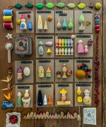 Content of 15 Grapat Lucky Lucky boxes mystery toy boxes lined up revealing the wooden toys inside.