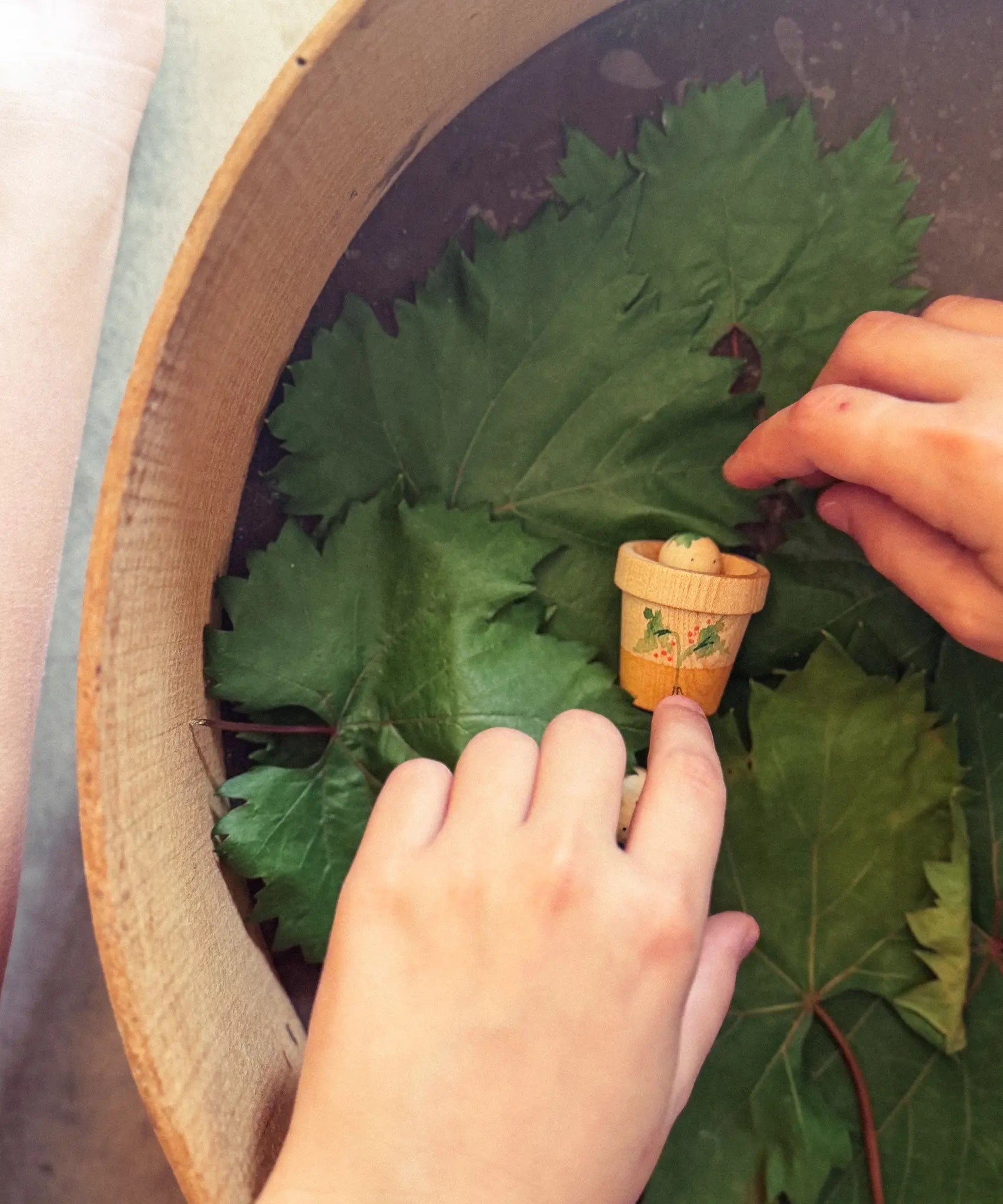 Child's hand playing with the Grapat Lucky Lucky mystery toy box number 12  little sprouts set of wooden toys. 