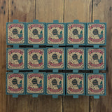 15 boxes of Grapat Lucky Lucky boxes mystery toy boxes lined up on a wooden floor with the surprise wooden toys hidden inside.