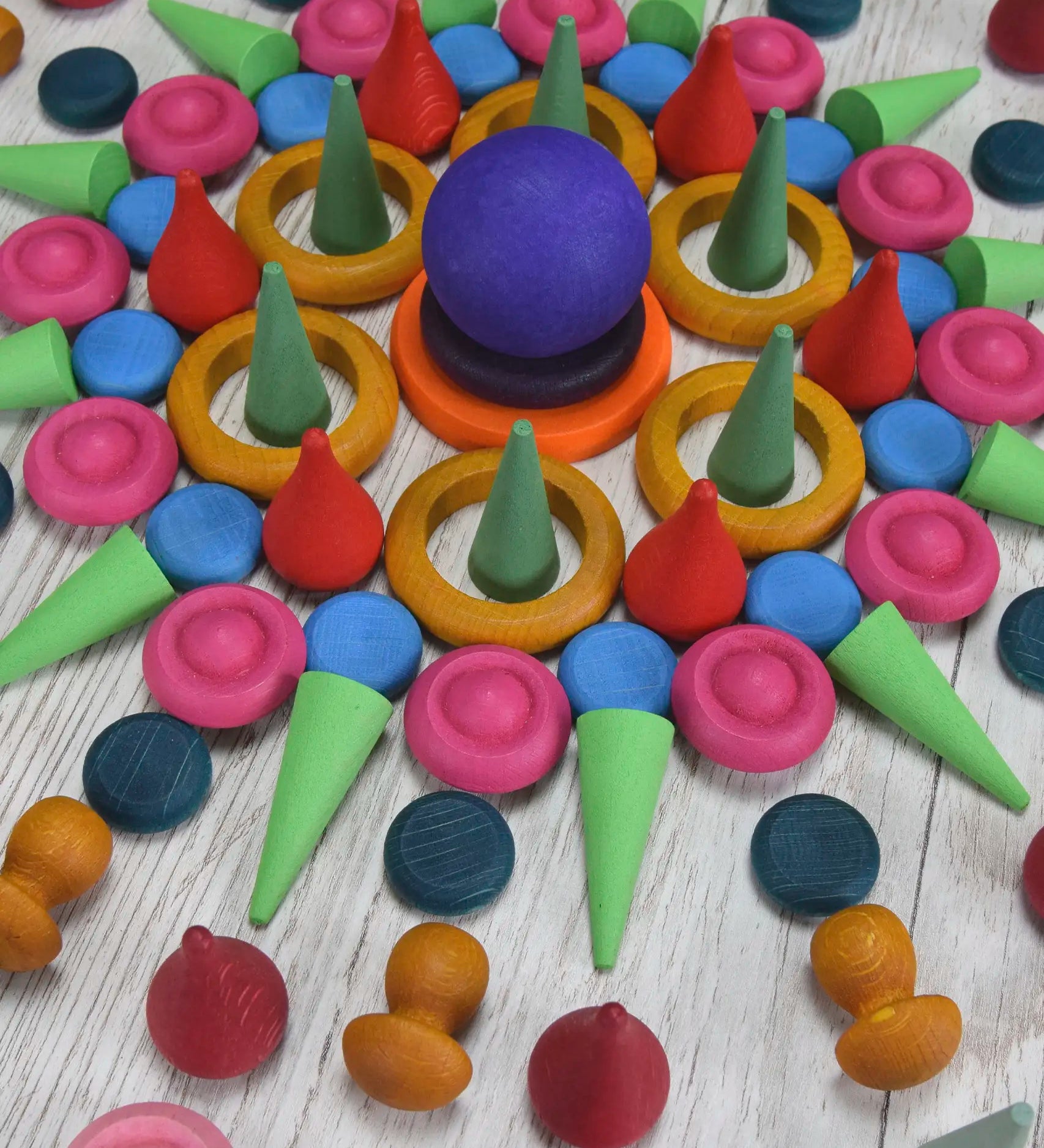 A decorative mandala pattern made from handcrafted wooden Grapat coloured mandala loose pieces 