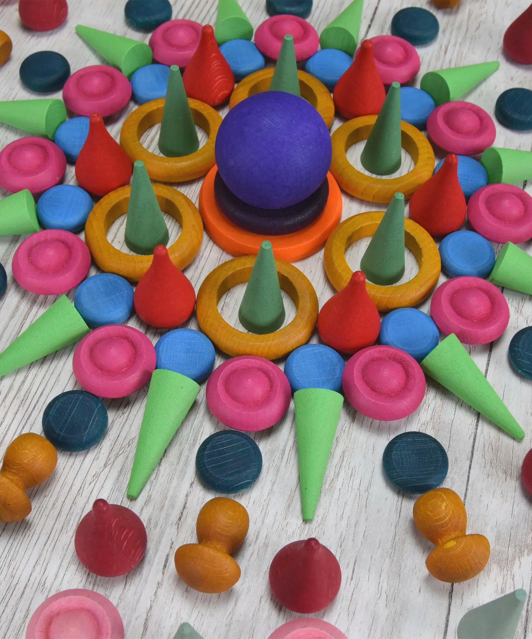 A decorative mandala pattern made from handcrafted wooden Grapat coloured mandala loose pieces 