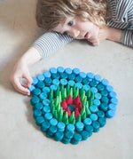 Child creating a mandala with Grapat mandala mini coins.