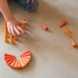Child playing with the Grapat 36x Mandala Orange Cone wooden pieces.