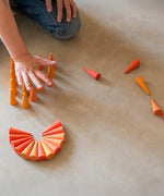 Child playing with the Grapat 36x Mandala Orange Cone wooden pieces.
