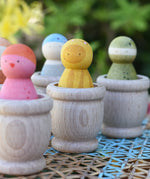 Grapat mates wooden loose part cups with animal crew peg dolls placed inside.