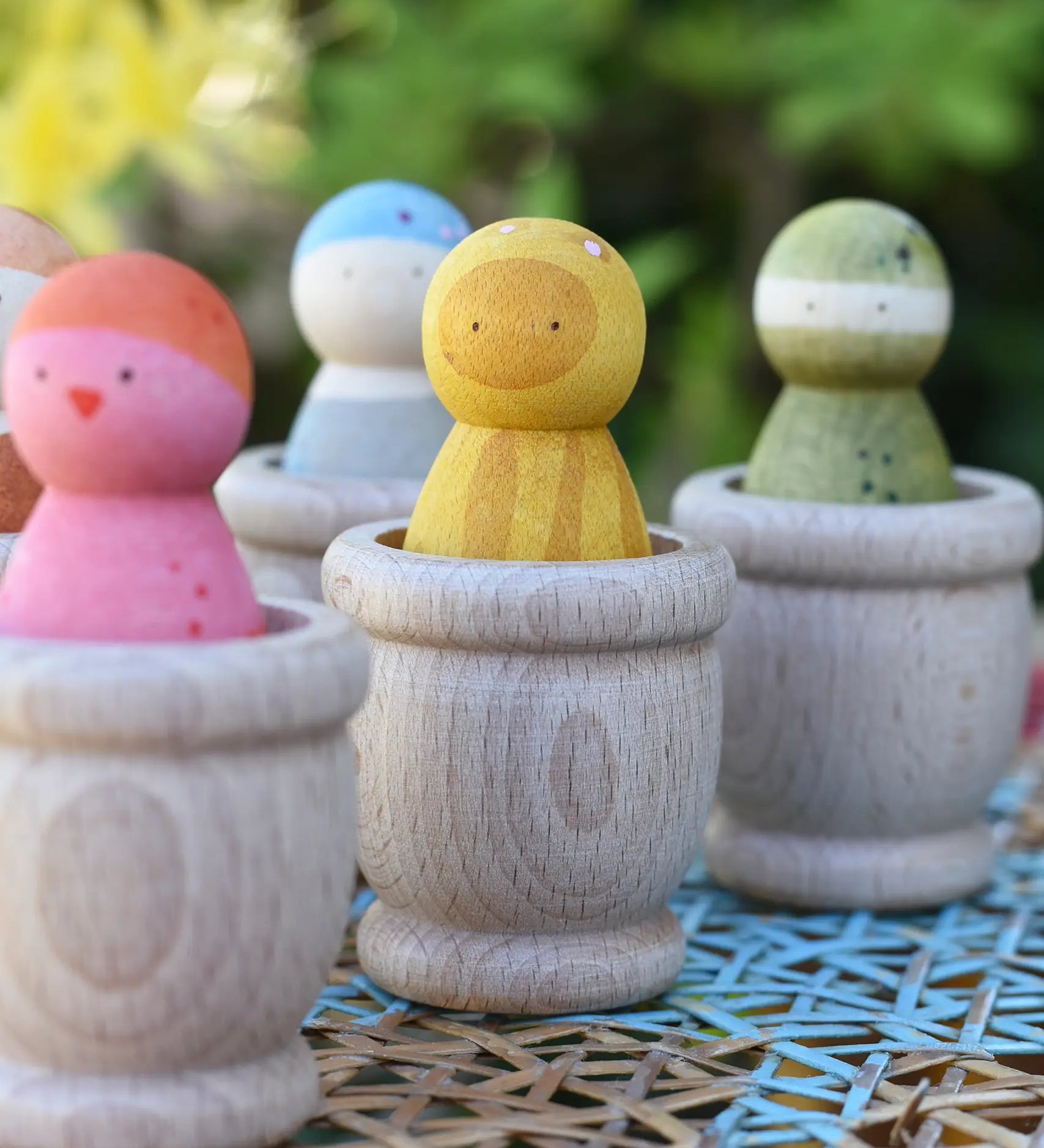 Grapat mates wooden loose part cups with animal crew peg dolls placed inside.