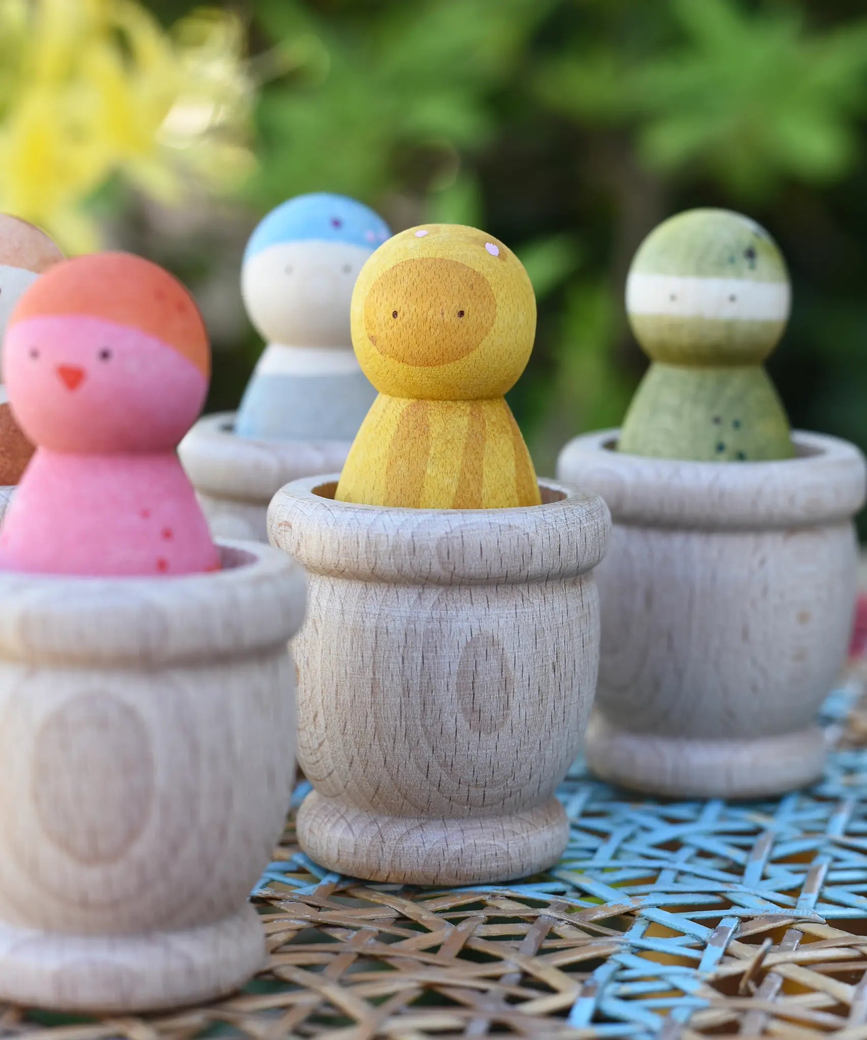 Grapat mates wooden loose part cups with animal crew peg dolls placed inside.