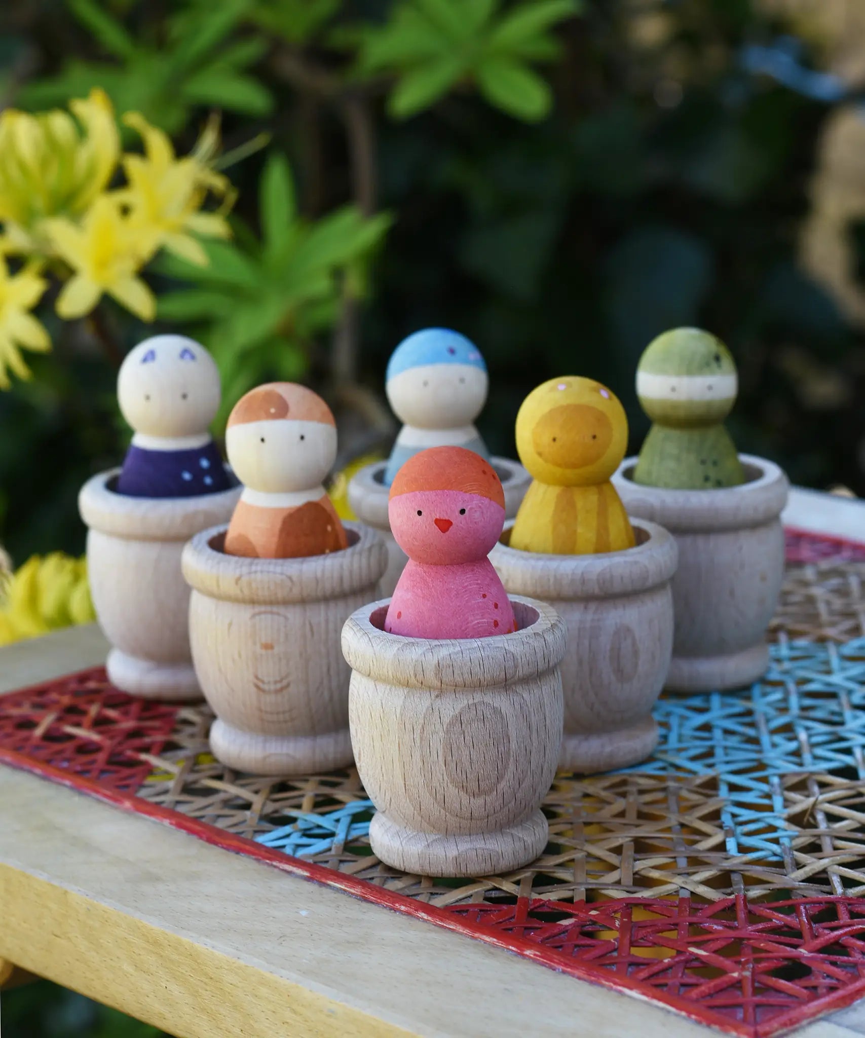 Grapat mates wooden loose part cups with animal crew peg dolls placed inside.