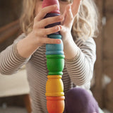 Child stacking Grapat mates rainbow coloured cups on top of each other. 