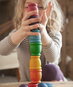 Child stacking Grapat mates rainbow coloured cups on top of each other. 
