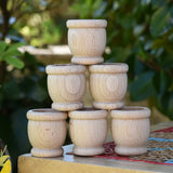 Grapat 6 mates wooden loose parts stacked up on a stool outdoors.