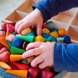 Child holding a bunch of Grapat handcrafted mini wooden mandala pieces in a Respiin basket