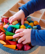 Child holding a bunch of Grapat handcrafted mini wooden mandala pieces in a Respiin basket