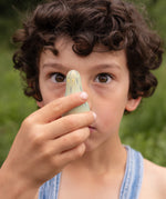 A child holding the green wooden monster peg doll from the Grapat 4th edition lucky lucky boxes showing the painted detail and scale
