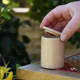 Grapat natural cup with lid, and adult's hand listing the lid off. 