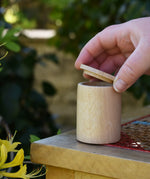 Grapat natural cup with lid, and adult's hand listing the lid off. 