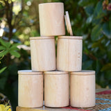 Grapat natural cups with lids stacked up on a stool outdoors. 