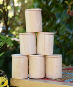 Grapat natural cups with lids stacked up on a stooll outdoors. 