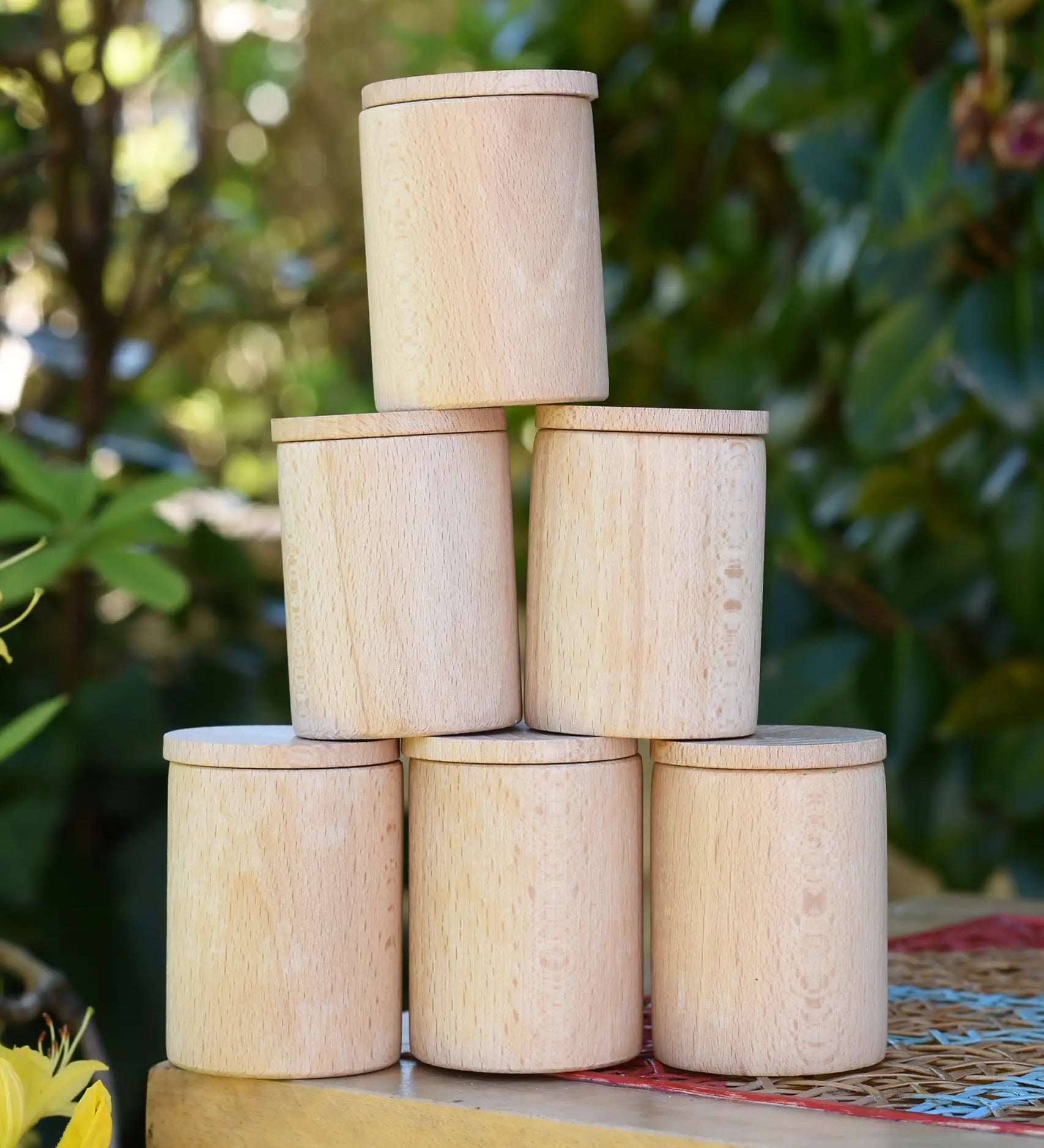 Grapat natural cups with lids stacked up on a stooll outdoors. 