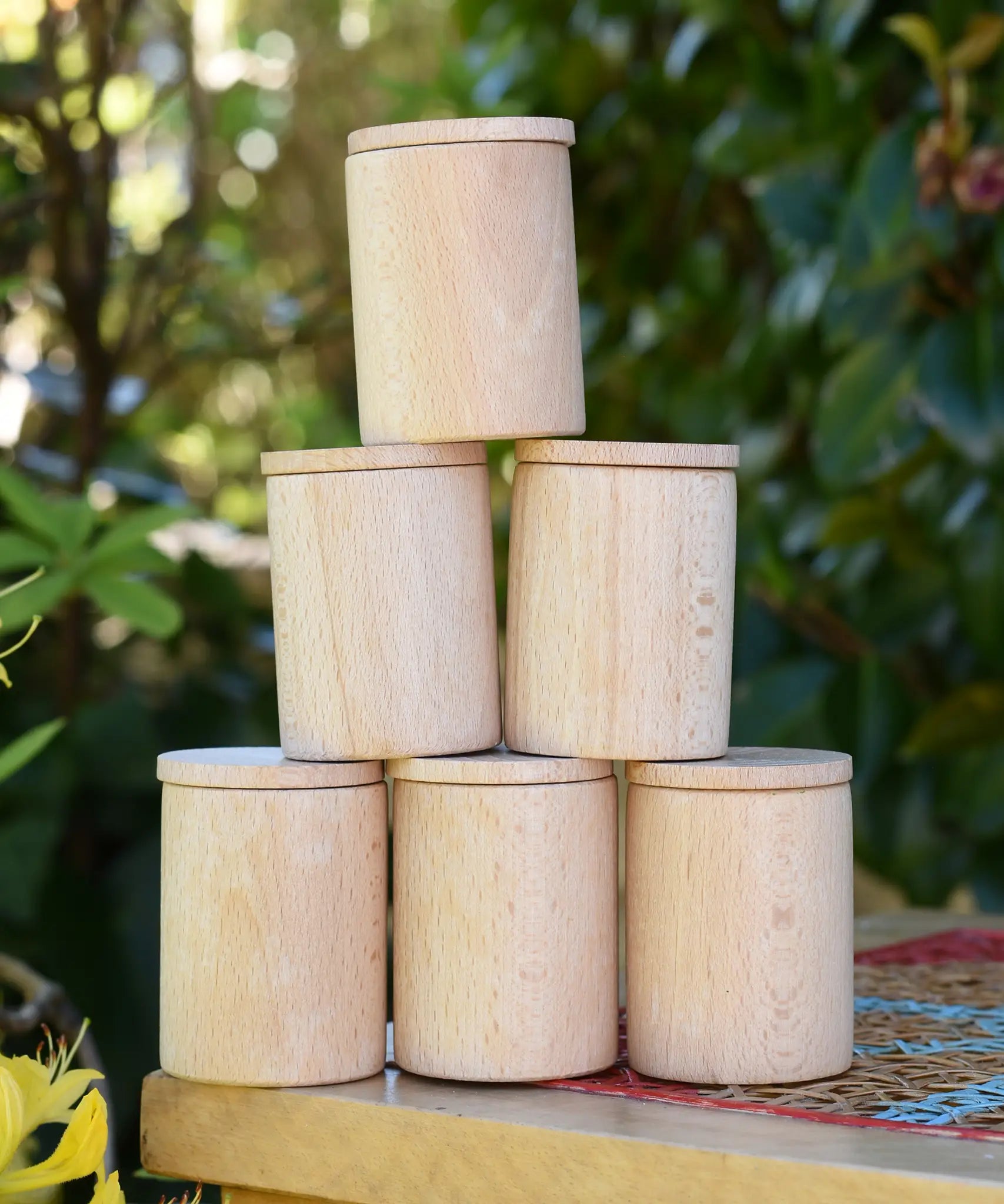 Grapat natural cups with lids stacked up on a stooll outdoors. 