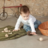 Child playing with a Grapat natural handcrafted wooden ball on a concrete surface