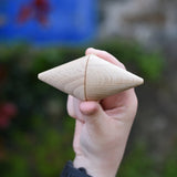 Two Grapat natural wooden cone in a child's hand. 