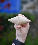Two Grapat natural wooden cone in a child's hand. 