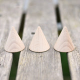 Three Grapat natural wooden cones placed on a wooden surface in the Babipur garden. 