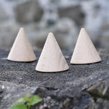 Three Grapat natural wooden cones placed on a stone wall. 