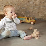 Child holding a Grapat handcrafted wooden half sphere loose pieces on a concrete surface