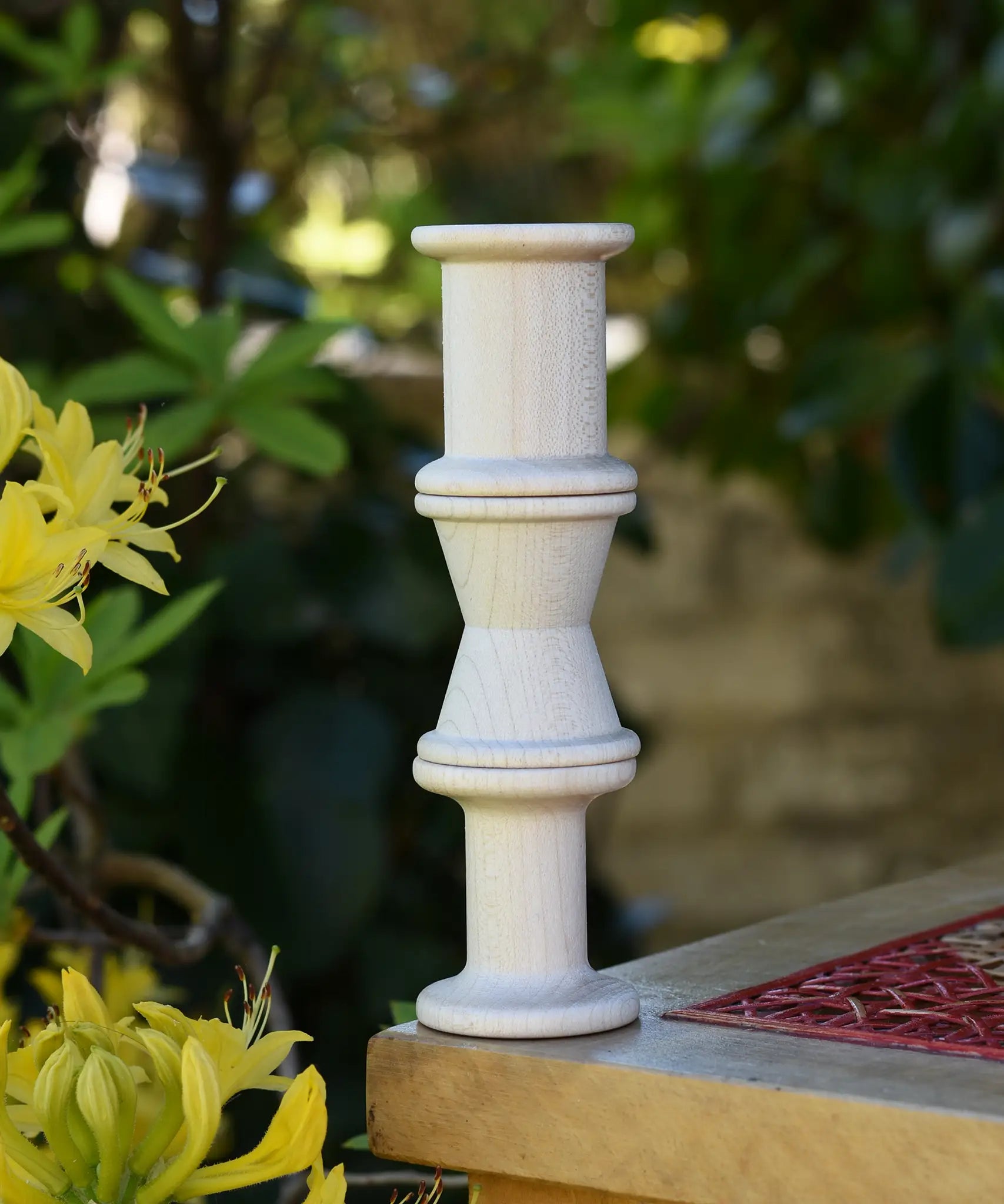 Grapat loose parts 3 natural wooden spools stacked on a stool. 