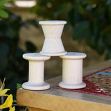 Grapat loose parts 3 natural wooden spools stacked on a stool. 