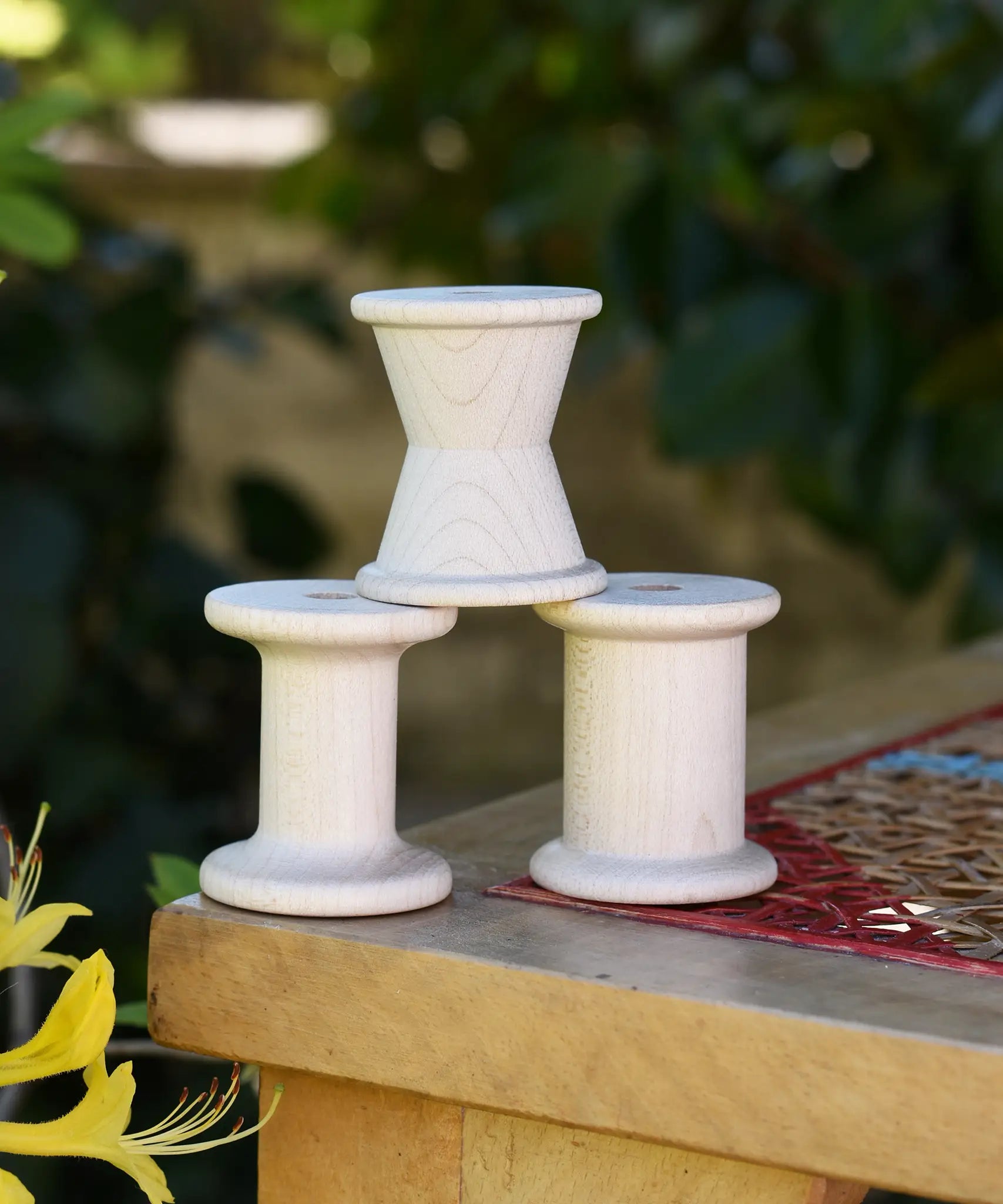 Grapat loose parts 3 natural wooden spools stacked on a stool. 