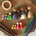 A collection of different sized Nins laid out on a wooden log slice. 