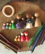 A collection of different sized Nins laid out on a wooden log slice. 