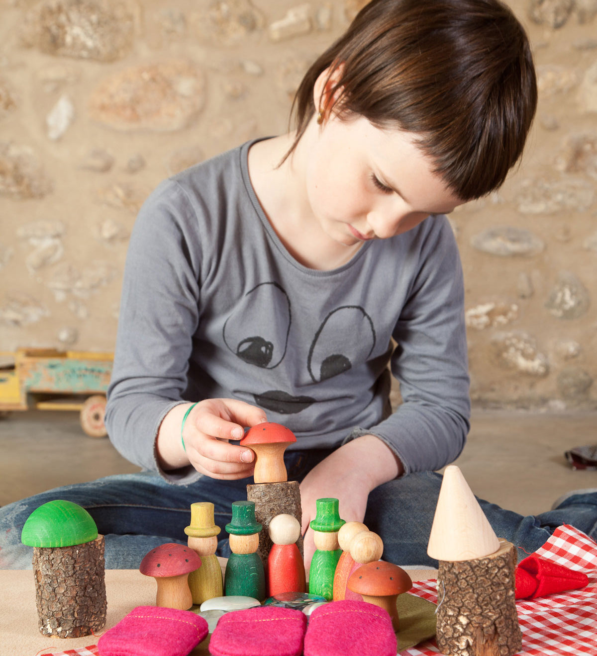 A child playing with the Grapat Nins® Of The Forest Peg Doll Play Set. These wooden toys are part of a wide range of open ended toys available at Babipur.  