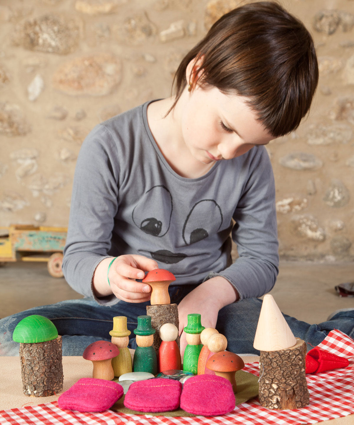 A child playing with the Grapat Nins® Of The Forest Peg Doll Play Set. These wooden toys are part of a wide range of open ended toys available at Babipur.  