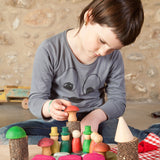 A child playing with the Grapat Nins® Of The Forest Peg Doll Play Set. These wooden toys are part of a wide range of open ended toys available at Babipur.  