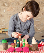 A child playing with the Grapat Nins® Of The Forest Peg Doll Play Set. These wooden toys are part of a wide range of open ended toys available at Babipur.  