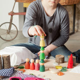 A child stacking Nins from the Grapat Nins® Of The Forest Peg Doll Play Set. These wooden toys are part of a wide range of open ended toys available at Babipur.  