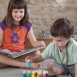 A child playing with the Grapat 12 Rainbow Nins wooden peg dolls. These wooden toys are part of a wide range of open ended toys available at Babipur.  