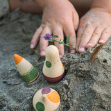 A close up of a child's hands next to Grapat Ooh-Lala! Set placed in snad. 