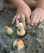 A close up of a child's hands next to Grapat Ooh-Lala! Set placed in snad. 