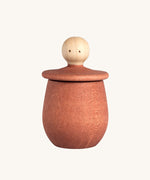 Grapat orange Little Things. A wooden top with eyes drawn on and an orange coloured pot to match. Grapat have a wide range of wooden toys and loose parts available at Babipur. 