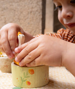 A child playing with the wooden goose and bowl from the Hello Summer set showing the scale of each piece. 